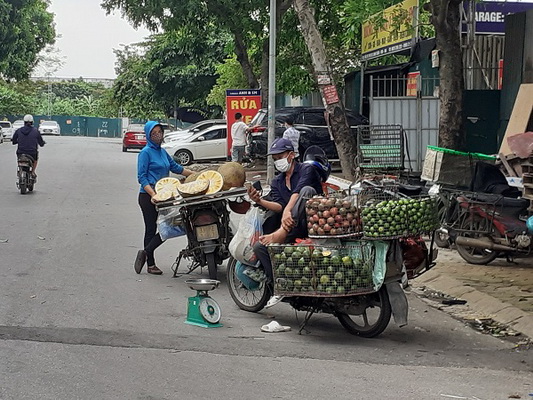 Nhiều người bán hoa quả còn tràn ra lòng đường để mời gọi khách.